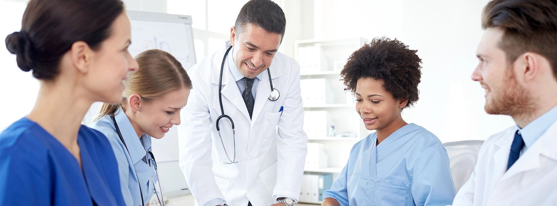 Physicians and nurses reviewing a patient plan together